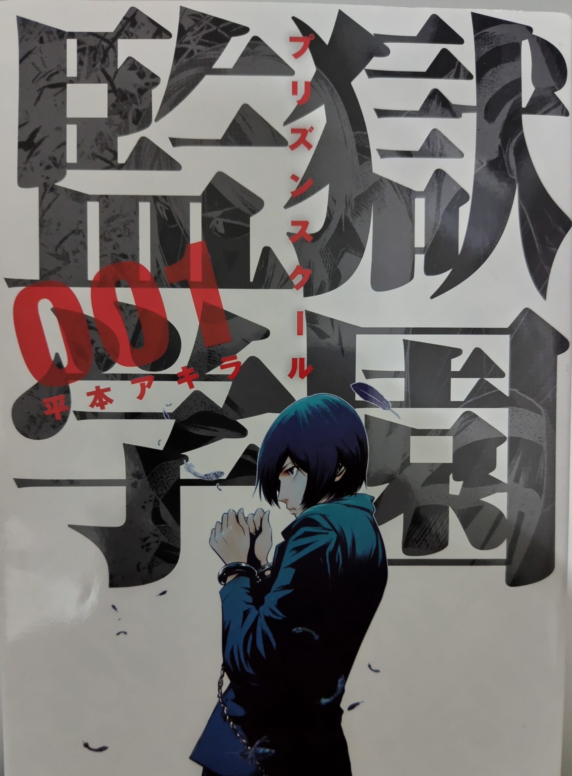 監獄学園』1巻の表紙。手錠をかけられ鎖に繋がれた主人公のキヨシ。