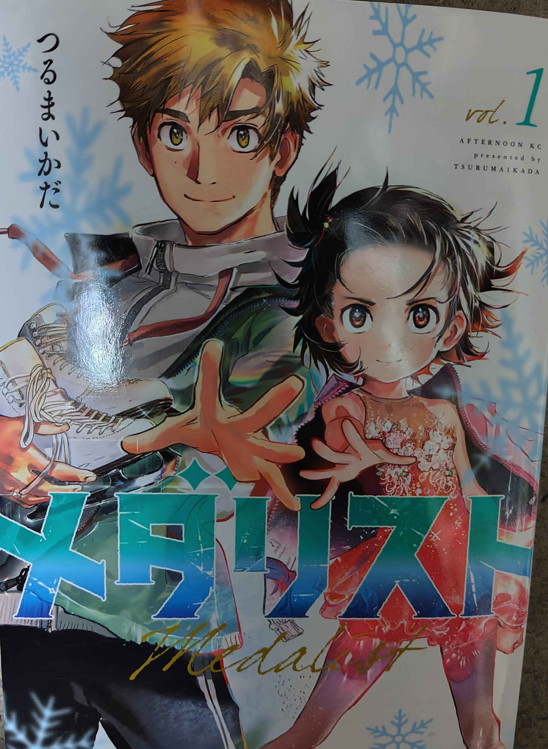 メダリスト　コミックス1巻の表紙。ポーズを決めるいのりと司。