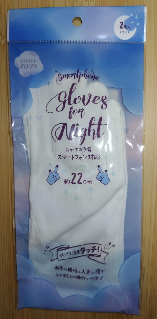スマホ操作に対応した綿100％のおやすみ手袋のパッケージ。白い手袋が2枚入りで、就寝時のハンドケア用として紹介されている。